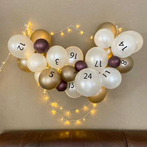 Adventskalender aus Luftballons in den Farben Metallic Weinrot, Metallic Weiß und Metallic Mandel. Die Ballons sind mit den Zahlen 1-24 bedruckt