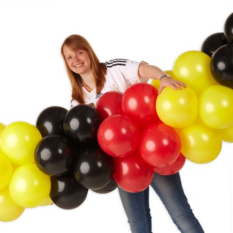 Luftballongirlande in schwarz, gelb rot mit Person