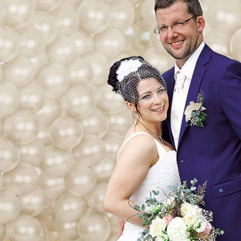 Brautpaar vor Fotohintergrund aufgeblasenen Ballons