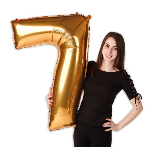 Goldener Folienballon Zahl "7", groß, neben einer Person zu sehen.